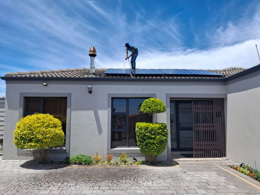 Two workers cleaning windows on a glass building facade using a lift platform, enhancing building aesthetics.
