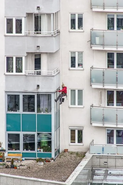 Profesionalni čistači prozora rade na neboderu u Abu Dhabiju, prikazujući urbanu arhitekturu.